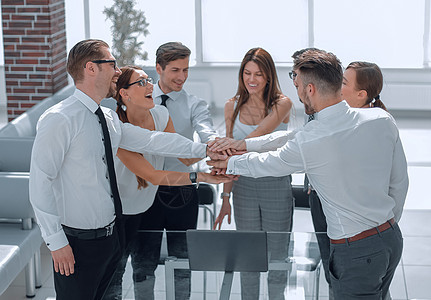 商业界的同事将双手折叠在一起会议朋友们办公室建设桌面女性男人手势胜利团队图片