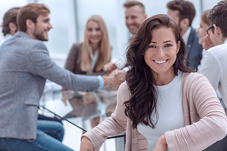 坐在会议室餐桌前的 笑着微笑的女商业妇女合作伙伴女士同事女性职业头脑男人职场工作图片