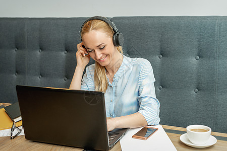 玩音乐的女孩女性正在家庭办公室的笔记本电脑上工作女孩思维机动性商业视频桌子技术网络博客女士背景