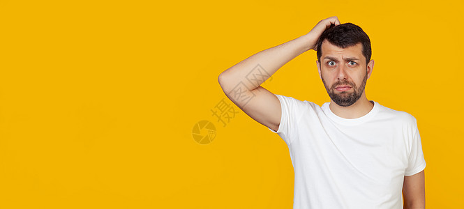 身穿白色 T 恤留着胡子的年轻人担心一个问题 手放在头上 对危机感到紧张和焦虑 站在孤立的黄色背景上压力套装管理人员男性办公室挫图片
