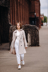 一个穿着灰色大衣的快乐时装女孩在城里走来走去城市享受街道奢华女士男人时尚眼镜休息外套图片