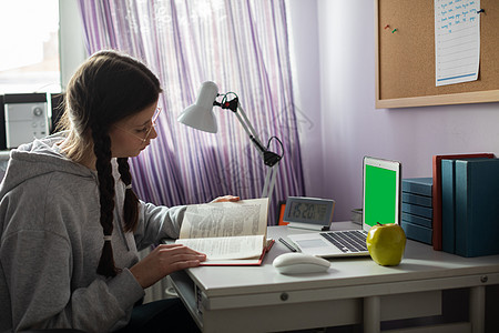 绿屏 家里有胸罩和眼镜的学生正在读一本书黑发角落绿色电脑窗户现代性老鼠肤色学校桌子图片