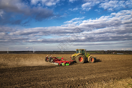 拖拉机为播种和耕种准备了土壤 农业和农艺学概念工作灰尘天空收割机车辆培育农田季节植物耕地图片