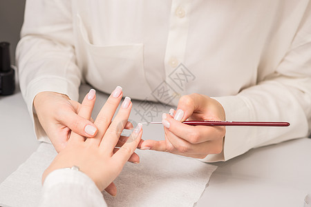 接受美容师法国美甲的妇女工作呵护手指温泉美甲师专家服务女性女士治疗图片