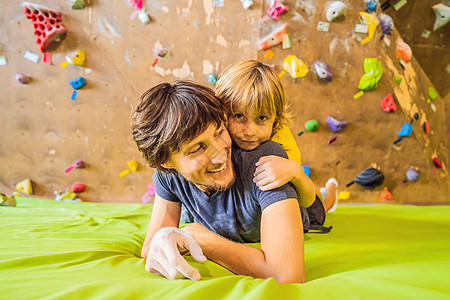 爸爸和儿子在攀岩墙 家庭运动 健康生活方式 幸福家庭训练孩子课程女儿青年健身房安全学习岩石运动装图片