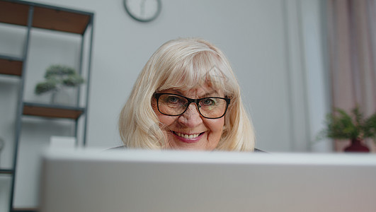 高级女商务人士在家庭办公室工作时戴眼镜 使用膝上型计算机在线网上研讨会祖母商业学习老年互联网自由职业者老人金融桌子退休图片