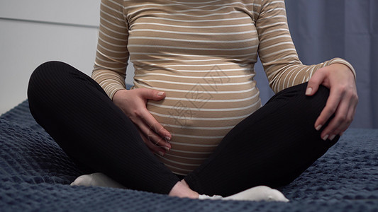 怀着眼镜的年轻孕妇在肚子上打探 卧室里的那个女孩躺在床上 摄像机放大产妇母亲保健女人家庭母性孩子腹部身体怀孕图片