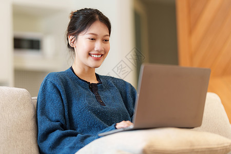 使用笔记本电脑的社交媒体来描绘亚洲年轻女性的肖像 生活方式 网上购物 沙发上放松喜悦休息室公寓长椅享受女儿女士窗户客厅枕头图片