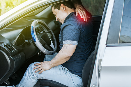 一个肌肉疼痛的汽车司机 一个男人在他的车里颈部疼痛的概念 一个背痛的精疲力尽的司机 一个在交通中肌肉疼痛的人图片