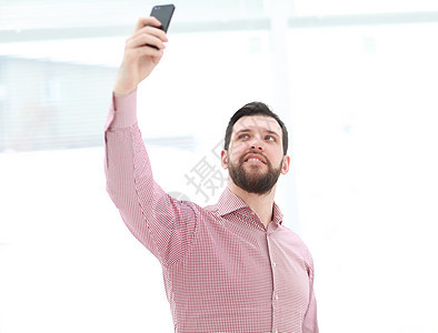 英俊男人在办公室拍自拍衬衫微笑职场职业公司照片经理技术商业人士图片