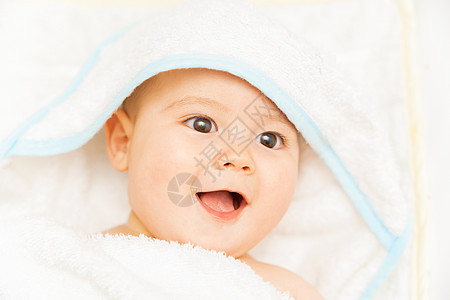 男婴在阳光明媚的白色卧室里穿着尿布和蓝色毛巾 刚出生的孩子在沐浴或淋浴后躺在床上放松 儿童托儿所 儿童纺织品和床上用品 有玩具熊图片