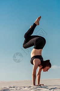 女孩在灰色背景下蹲的侧面视图灵活性运动员平衡海滩保健呼吸反转屁股练习女士图片