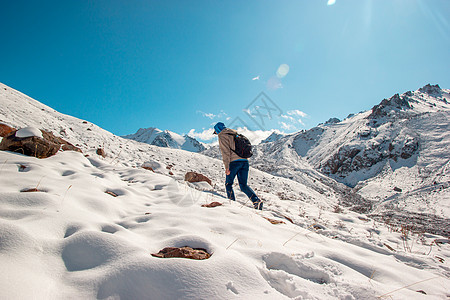一个人在雪坡上升起 到冬天的山峰季节顶峰训练旅行太阳踪迹背景山脉游客胡须图片