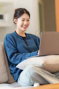 使用笔记本电脑的社交媒体来描绘亚洲年轻女性的肖像 生活方式 网上购物 沙发上放松长椅互联网家具享受女儿喜悦酒店微笑房间枕头图片