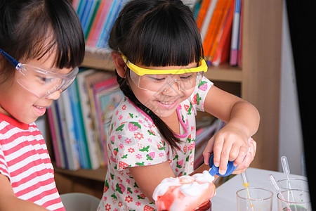 孩子们在教室里学习和做科学实验 两个小姐妹在进行家庭教育的科学实验 为孩子们在家进行简单有趣的科学实验滴管孩子课堂女孩液体烧瓶实图片