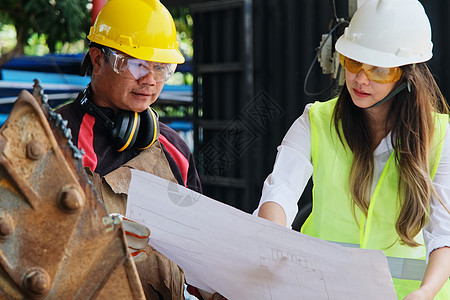 亚洲工程经理和机械工人在讨论和检查工厂的制造过程时戴着头盔工作图片