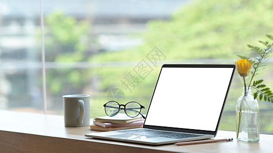 现代家庭办公室 有电脑笔记本电脑 书籍 咖啡杯和窗户附近的木制桌子上的眼镜图片
