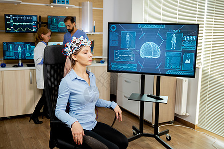 在屏幕上看到有头部扫描装置和脑活动的妇女病人在屏幕上看到头脑女士网络耳机监视器波浪疾病学习实验室医生图片