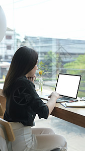 年轻女性自由职业者用电脑笔记本在线工作的回视高清图片