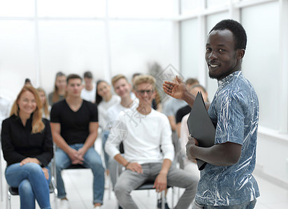 青年男子站在商业课程学生面前站着的青年男子们大学学习职业商务创业经理教练合作扬声器参与者图片