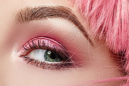 粉红色时尚眼部化妆特写宏 富有表现力的妆容 明亮的夏日眼影 洋红色头发 闪亮的皮肤图片