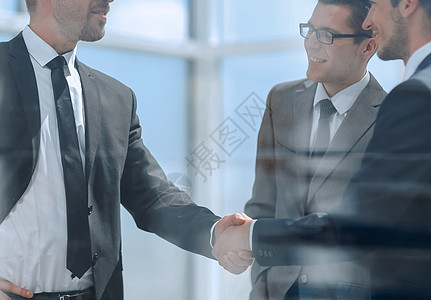 在现代办公室与商业伙伴进行握手工作男性合同问候语商务成人交易协议团队会议图片