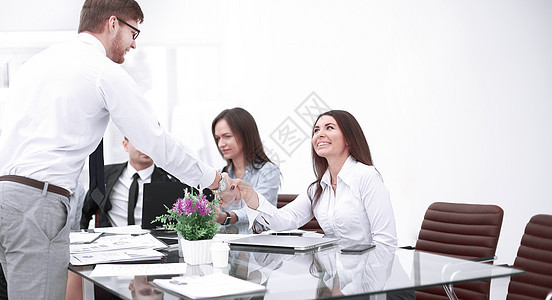 男人和女人伴侣在桌子上握手 保持眼神接触顾问工作交易公司会议经理导演管理人员工人合同图片