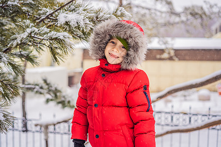 快乐的男孩玩雪 可爱的孩子在冬季公园里扔雪 寒假快乐 冬季时尚幸福活动享受天气乐趣喜悦季节男生闲暇衣服图片