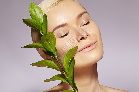 美貌女性应用有机化妆品 皮肤和健康 清洁皮肤的模型 保健 与叶子合影图片