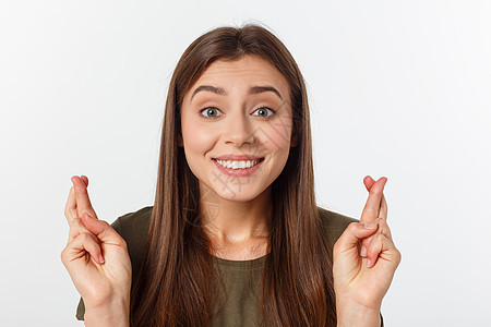 特写肖像希望美丽的女人交叉她的手指 睁开眼睛 希望 问最好孤立在灰色的墙壁背景上快乐微笑白色女孩学生头发女士手势工作室成人图片