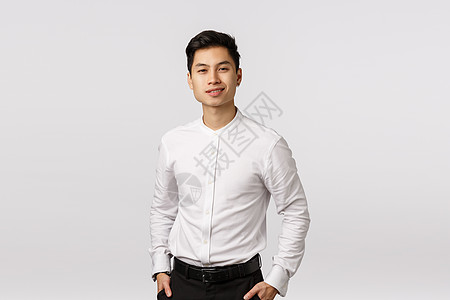 商业 成功和幸福的概念 英俊的年轻亚洲商务人士从事财务工作 幸运的是 手放在口袋里 微笑着自信 站在白色背景经济成人人士工人职业图片