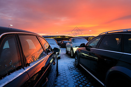 红色日落背景的停车场车厢里的车图片