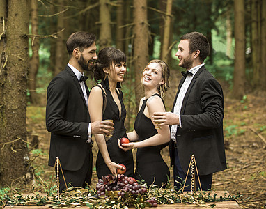 两对身穿商业西装的年轻夫妇 在树林里野餐图片