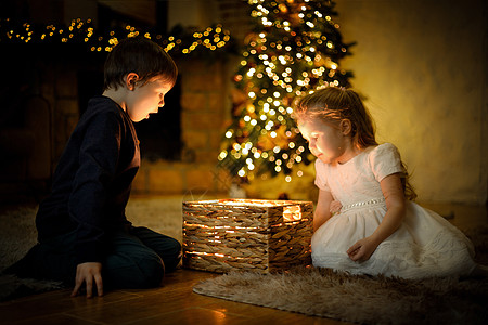 跳出舒适圈孩子们在圣诞节内地开了一个神奇的新年礼物 里面有圣诞树和羊毛圈背景