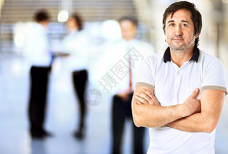 一个英俊商务人士的肖像 在他的团队面前团体管理人员经理工作办公室公司人士员工衬衫企业家图片