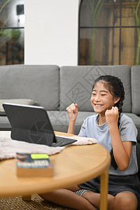 令人兴奋的亚洲女孩在家中网上虚拟课程上学习的同时 在电脑平板上穿衣看电脑片图片