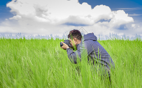 男人在田野里用相机拍照 摄影师在田野里拍照 拉丁裔男人在绿色田野里拍照照片年轻人场地摄影天空旅行人场山脉肖像冒险图片