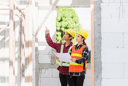 建筑师和客户在施工现场讨论建筑蓝图的计划合作项目成人建筑学建设者领班人士职场男人会议图片