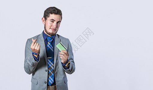 拿着信用卡的商务人士被隔离 穿着西装的男人带着信用卡微笑 男人拿着信用卡的概念图片
