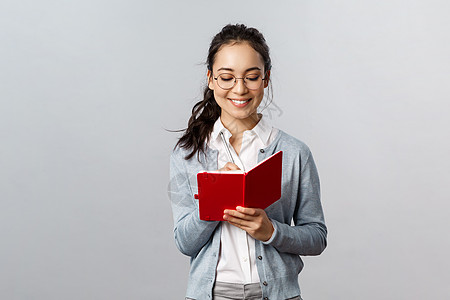 教学 教育和大学生活方式概念 戴眼镜微笑聪明的亚洲女性 导师做笔记 准备上课 在笔记本上写下演讲 在计划者中制定时间表学生学习商图片