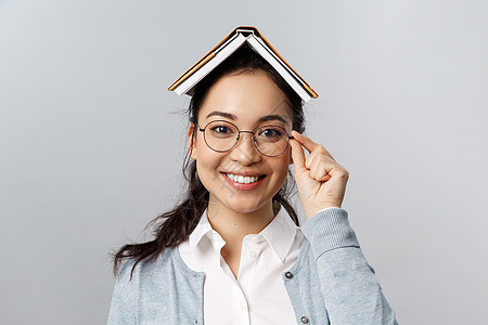 教育 大学和人的概念 呆在家里远程学习 戴眼镜 头上拿着书或计划书 学习 准备检疫结束后考试的快乐亚洲女性工作室商业老师女孩自由图片