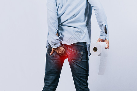 手拿卫生纸摸屁股的男人 有腹泻问题的男人 孤立背景下有痔疮问题的男人图片