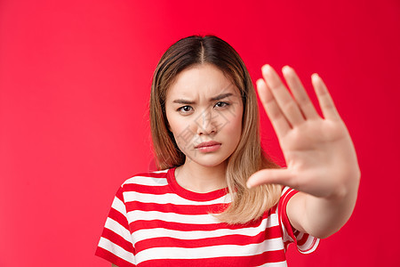 表情严肃 惊慌失措 愤怒的亚洲女人把手向前拉 没有迹象 要求和禁止表现粗鲁 站在红色背景强烈拒绝糟糕的提议 站在红色背景女士女孩图片