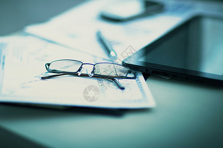 文件上戴眼镜的工作场所的商业财务分析财富统计利润图表办公室贸易眼镜经济公司蓝色图片