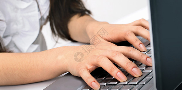 女商务人士在笔记本电脑键盘上打字图片