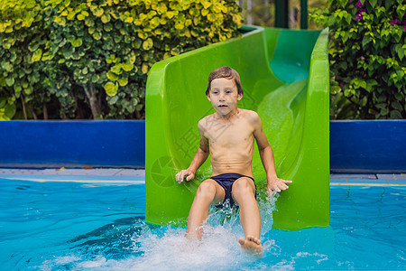 小男孩或小男孩在夏天滑下水滑雪后 游泳池里有乐趣水槽享受游泳幸福乐园公园游客喜悦水池娱乐图片