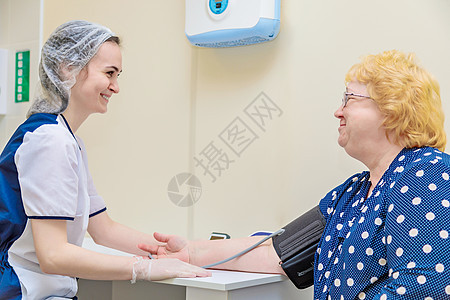 多科诊所的护士用一个装置测量一名妇女血压 并进行医疗护理检查脉冲心脏病学压力卫生保健工作仪表药品诊断图片