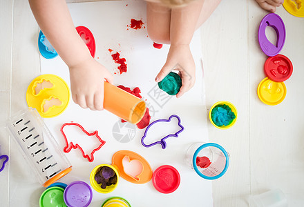 幼稚园的小孩在玩彩色塑胶黏土桌子孩子艺术孩子们学校面团课堂玩具女孩图片