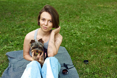 一个正方形的可爱女孩在街上抱着一只约克夏犬 在公园里和你的小狗拥抱喜悦朋友成人猎犬女性乐趣动物微笑快乐友谊图片