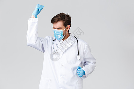 医院 医护人员 covid-19 治疗理念 医生感觉像冠军 戴着磨砂医用口罩和手套 握拳欢呼 欢欣鼓舞 战胜疾病 治疗病人图片